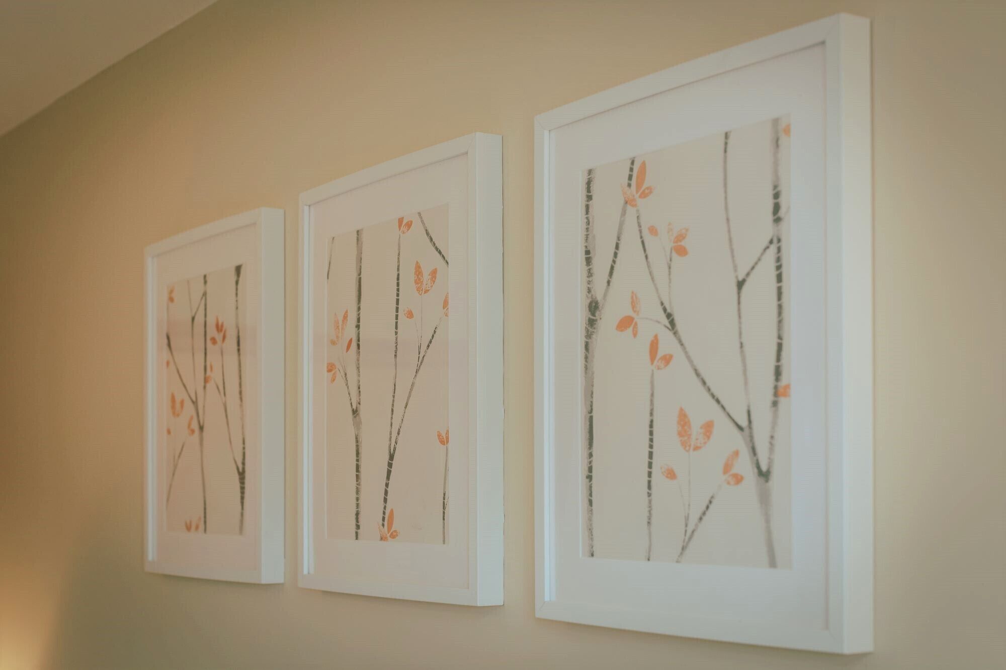 Tres obras de arte enmarcadas sobre una pared.