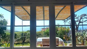 Una habitación con un amplio ventanal que da a un viñedo y un cielo despejado.