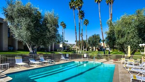 A swimming pool with lounge chairs and palm trees. - Corsican Villas 2BD Condo- Near Living Desert (Palm Desert)