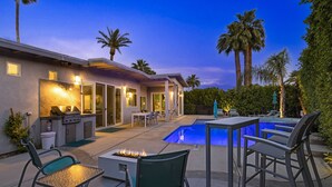 Eine moderne Außenpatio mit Pool, Sitzgelegenheiten und Grillbereich.