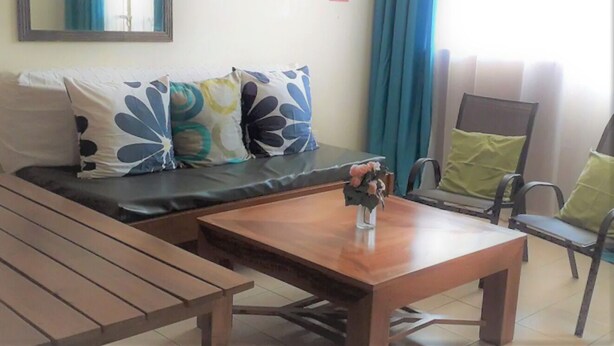 Un salon avec un canapé, une table basse en bois et un fauteuil.