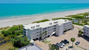 A hotel with a rooftop pool overlooking a beach and ocean. - Sanibel Surfside 115: Gorgeous Gulf Front Oasis! (Sanibel)