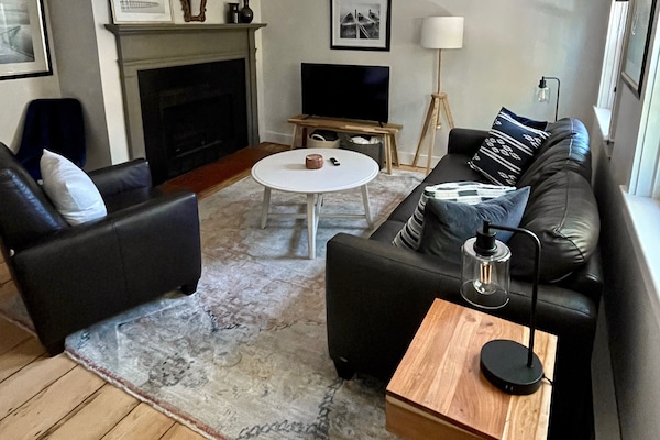 The living room has a leather couch, recliner, smart TV, and electric fireplace.