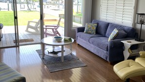 A spacious living room with a blue sofa, a yellow chair, and a wooden coffee table.