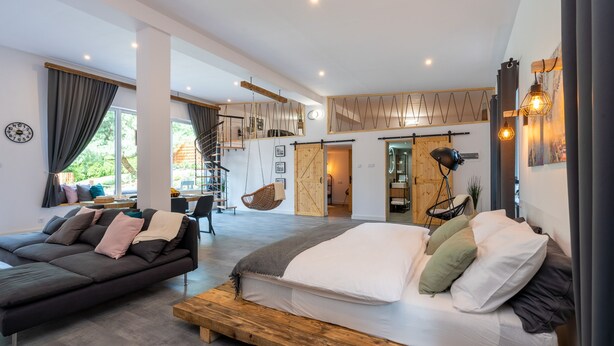 A modern bedroom with a large bed, a sofa, and a dining area. - Secret Loft by Villa Jurka (Paszkówka)