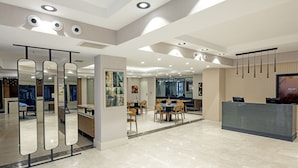 A modern hotel lobby with a reception desk, seating area, and artwork on the walls. - Merlin Hotel Istanbul (Istanbul)