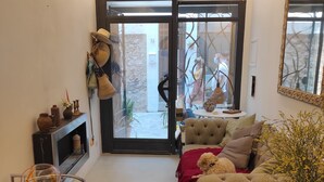 A cozy living room with a sofa, a wicker chair, a glass coffee table, and a decorative rug. - Bright and airy townhouse (Soller)