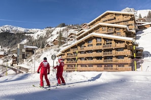 Estación de esquí con edificios de madera, pistas de nieve y cielo despejado.