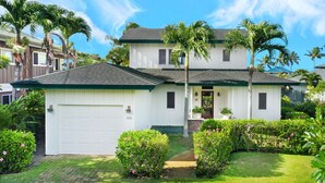 A two-story house with a white exterior, a garage, and a front porch.