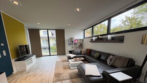 A modern living room with a sectional sofa, a coffee table, and a TV on a stand.