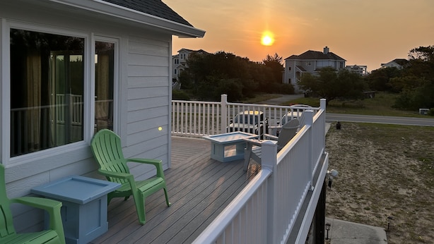 A deck with outdoor furniture and a view of the sunset. - E-SEA-LIVIN' Oceanside Coastal Cottage in Corolla, 4 min walk to the beach! (Corolla)