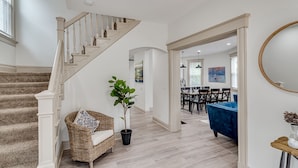 A spacious living area with a staircase, a dining area, and a blue sofa. - ROOMY, COMFY, and CONVENIENT Historical Home (Cincinnati)