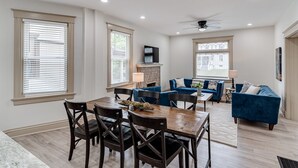 A spacious living room with a blue sofa set, a dining area with wooden chairs and a table, and large windows with blinds. - ROOMY, COMFY, and CONVENIENT Historical Home (Cincinnati)