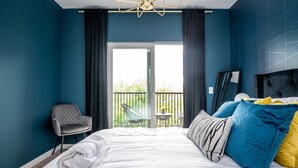 A hotel room with a large bed, a chair, and a balcony with a view. - Cozy Modern Home in Downtown Atlanta (Atlanta)