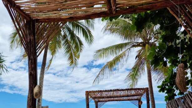 A beachside lounge with a thatched roof, wooden furniture, and a view of the ocean. - B&B Ayla Beach House (Zanzibar Kiwengwa)