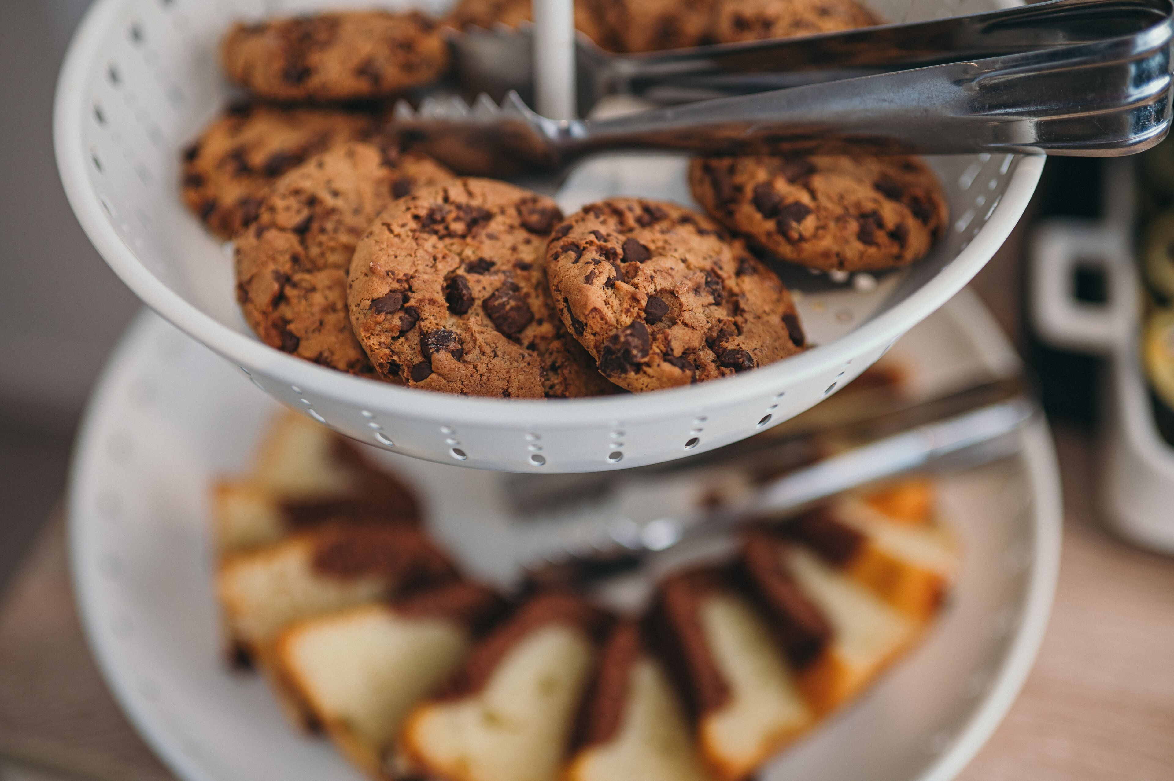 Un colador blanco lleno de galletas con chispas de chocolate.