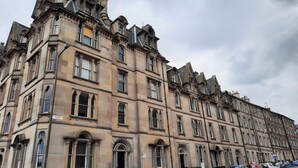 A historic building with multiple windows and a street sign indicating "Cornwall Street." - Cornwall Street [297] is a Spacious and charming apartment close to Usher Hall (Edinburgh)