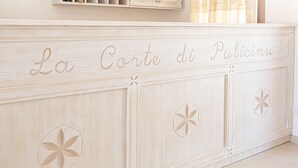 A wooden cabinet with carved floral designs and the text "La Corte di Pulicinu". - La Corte di Pulicinu (Arzachena)