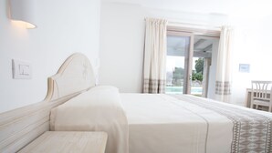 A hotel room with a large bed, a bench, and a view of the outdoors. - La Corte di Pulicinu (Arzachena)