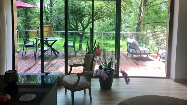 Una sala de estar moderna con un amplio ventanal corredero que da a una terraza exterior.