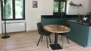 Una cocina moderna con armarios color turquesa, una mesa de comedor de madera y dos sillas.