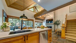 Una cocina amplia con armarios de madera, una isla grande y una chimenea de piedra.
