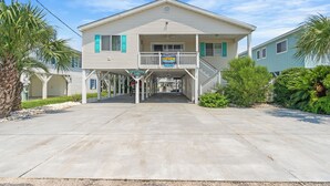 A two-story building with a balcony, a sign for Elliott's Restaurant, and a Driftwood Too sign. - Driftwood Too - 4 Bed/2 Bath Home on the Channel in Cherry Grove (North Myrtle Beach)