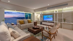Una sala de estar moderna con un juego de sofá, una mesa de centro y un televisor sobre un mueble.