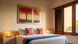 Habitación de hotel con una cama, mesitas de noche, un cuadro y una ventana con persianas.