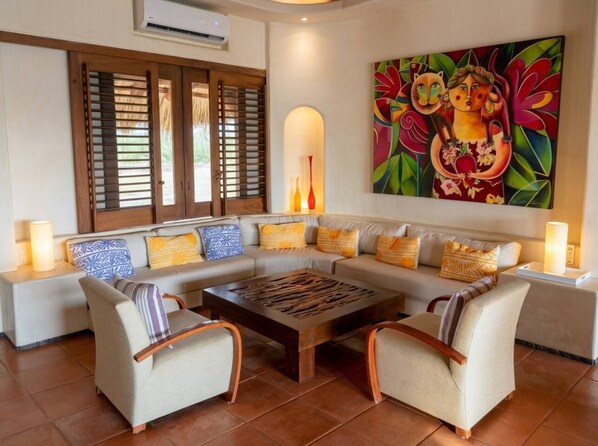 A living room with a sofa set, a coffee table, and a painting on the wall.