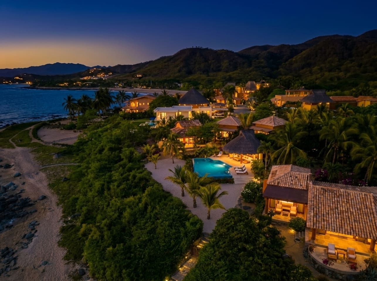 A resort with multiple buildings, a swimming pool, and a beach.