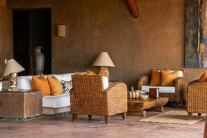 A cozy lounge area with wicker furniture, white sofas, and orange cushions. - Casamar, beach front estate on Troncones Point (La Majahua)