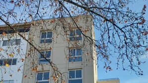 A multi-story building with a classical facade, featuring three large wooden doors and a small balcony. - Divino Loft - Mas Centrico Imposible (Salta)