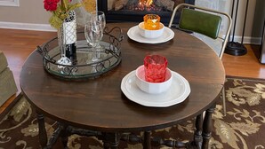 Ein Esstisch mit Kamin, Dekoration und einem Blumenstrauß.