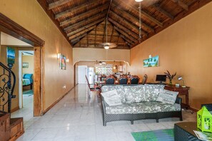 Relax in this inviting living area with a sofa, dining table, and framed artwork.