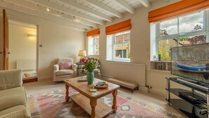 A cozy living room with a wooden coffee table, a sofa, and a television.