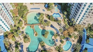 Eine Vogelperspektive eines Resorts mit mehreren Schwimmbecken, Palmen und Liegebereichen.
