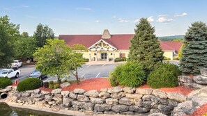 A building with a red roof, stone walls, and a parking lot.