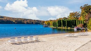 Relax on the lakeside beach with lounge chairs and enjoy the serene surroundings.