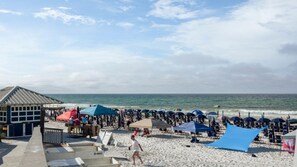 A beach with umbrellas, chairs, and a lifeguard tower.