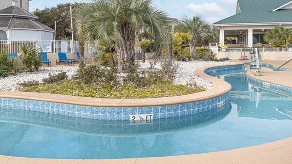 Relax by the pool surrounded by lush gardens and lounge chairs.