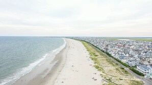 A coastal residential area with a beach, houses, and a road. - Perfect getaway for large families who love the woods and beach!! (Woodbine)