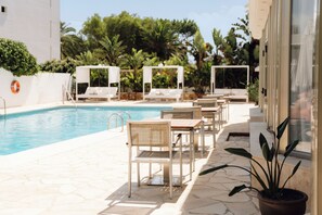 A poolside area with lounge chairs and tables, a lifebuoy, and potted plants. - Bluesea Paraiso Beach (Santa Eulalia del Rio)
