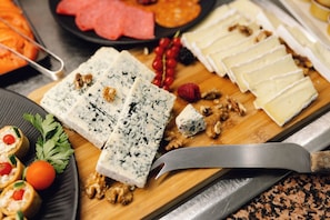 A variety of cheeses and nuts on a wooden board with a knife. - Bluesea Paraiso Beach (Santa Eulalia del Rio)