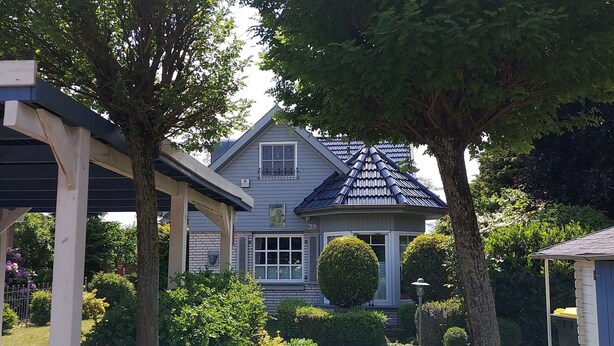 A residential house with a covered porch, a brick pathway, and a metal gate. - Ferienhaus am Dümmer (Hüde)