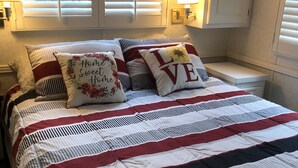 A neatly made bed with striped bedding and two pillows, one with "Home Sweet Home" and the other with "LOVE". - 5 miles from Disney & Universal! (Kissimmee)