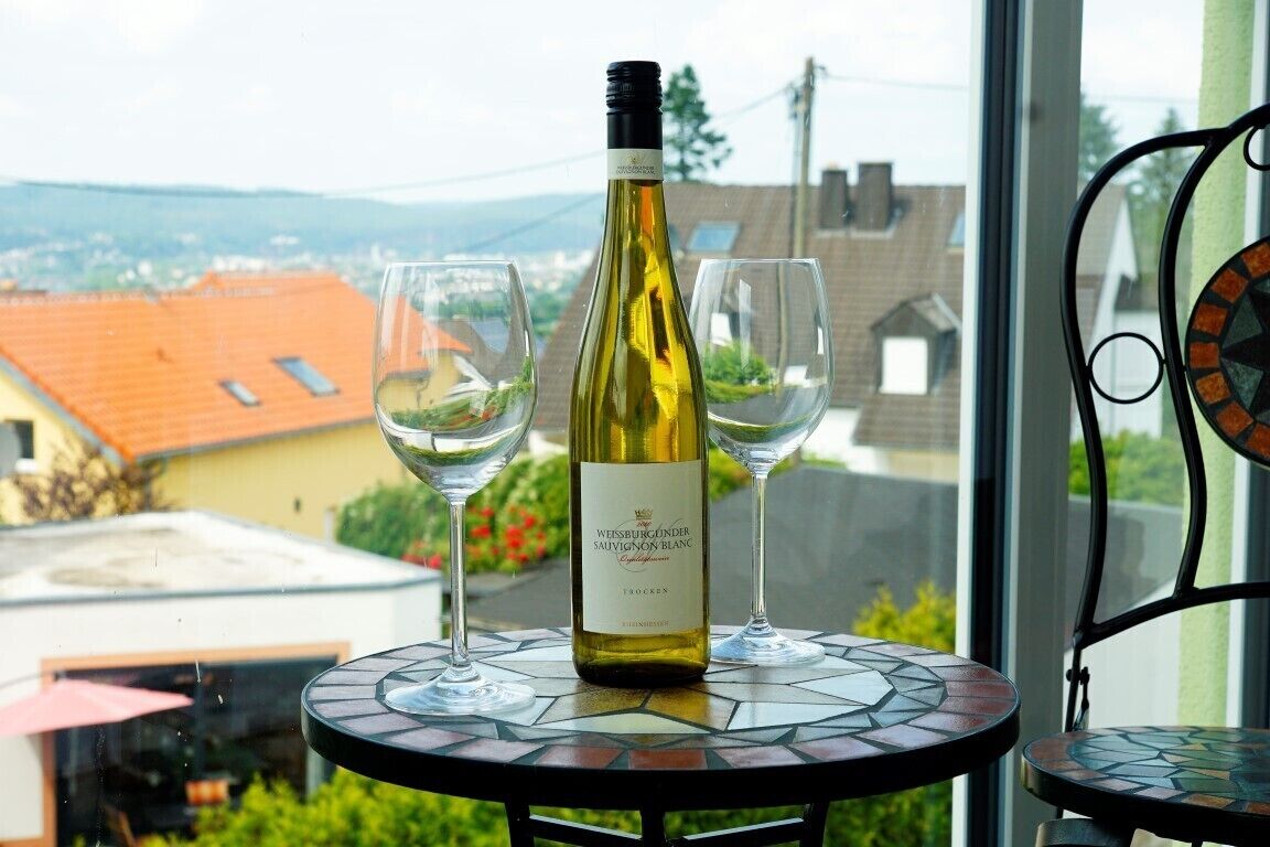 Eine Flasche Weissburgunder Sauvignon Blanc auf einem Tisch mit zwei Gläsern.