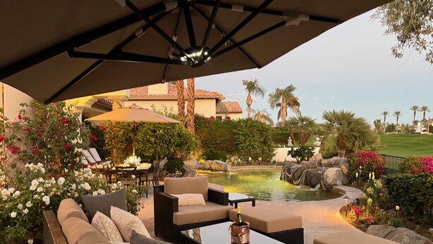 Un espace extérieur aménagé avec une terrasse, une piscine, des chaises longues et un coin repas.