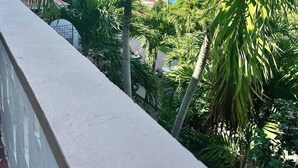 Un balcon avec vue sur une plage et des voiliers.
