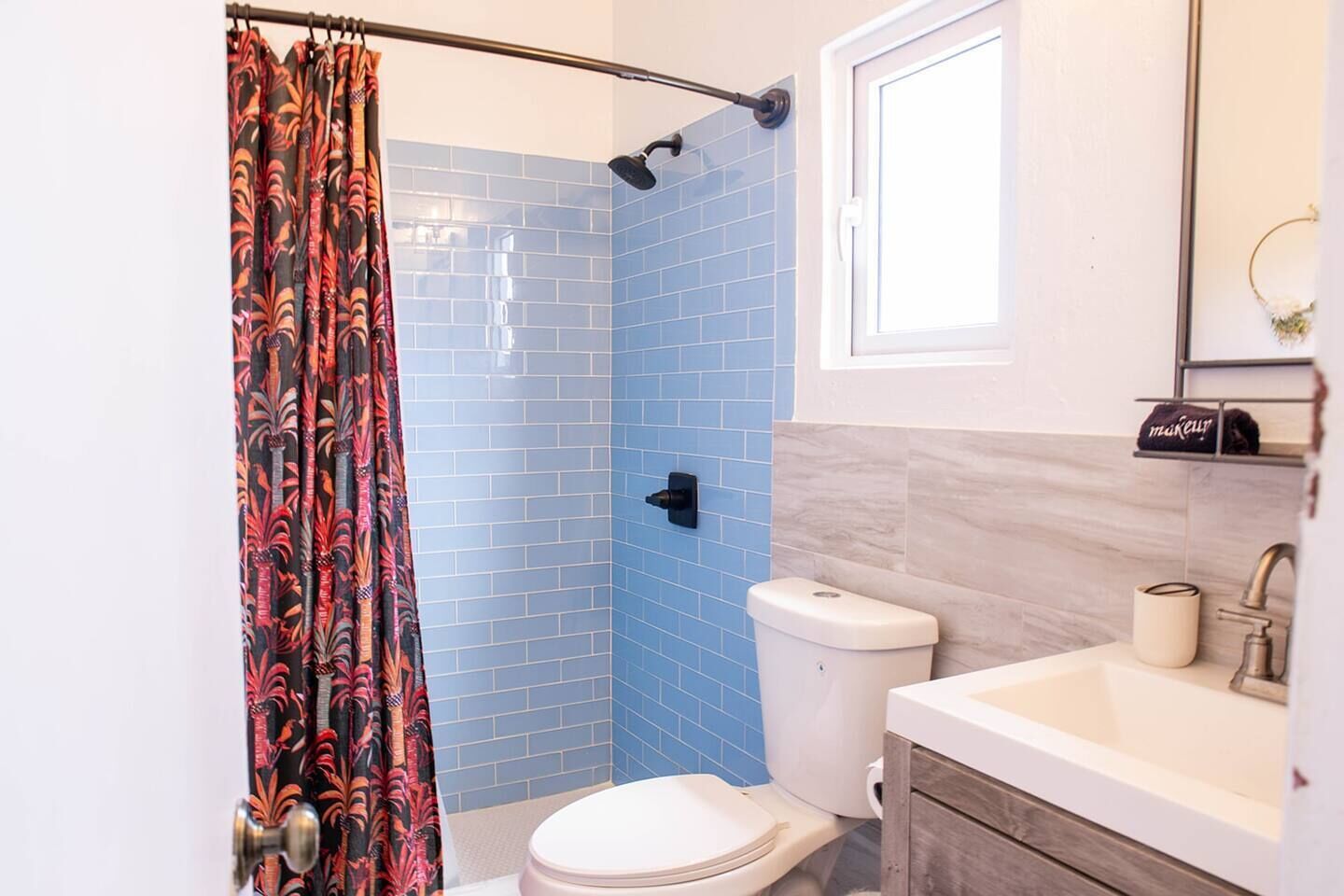 A bathroom with a shower, toilet, and sink.